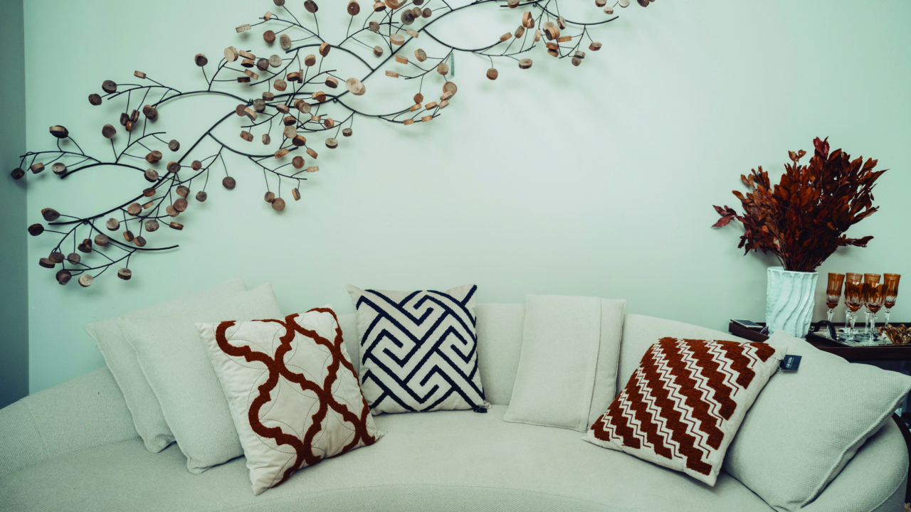 Nessa composição, objetos de decoração e capas de almofada da Laís Aliski Casa em tons terrosos ajudam a aquecer o ambiente majoritariamente branco.
