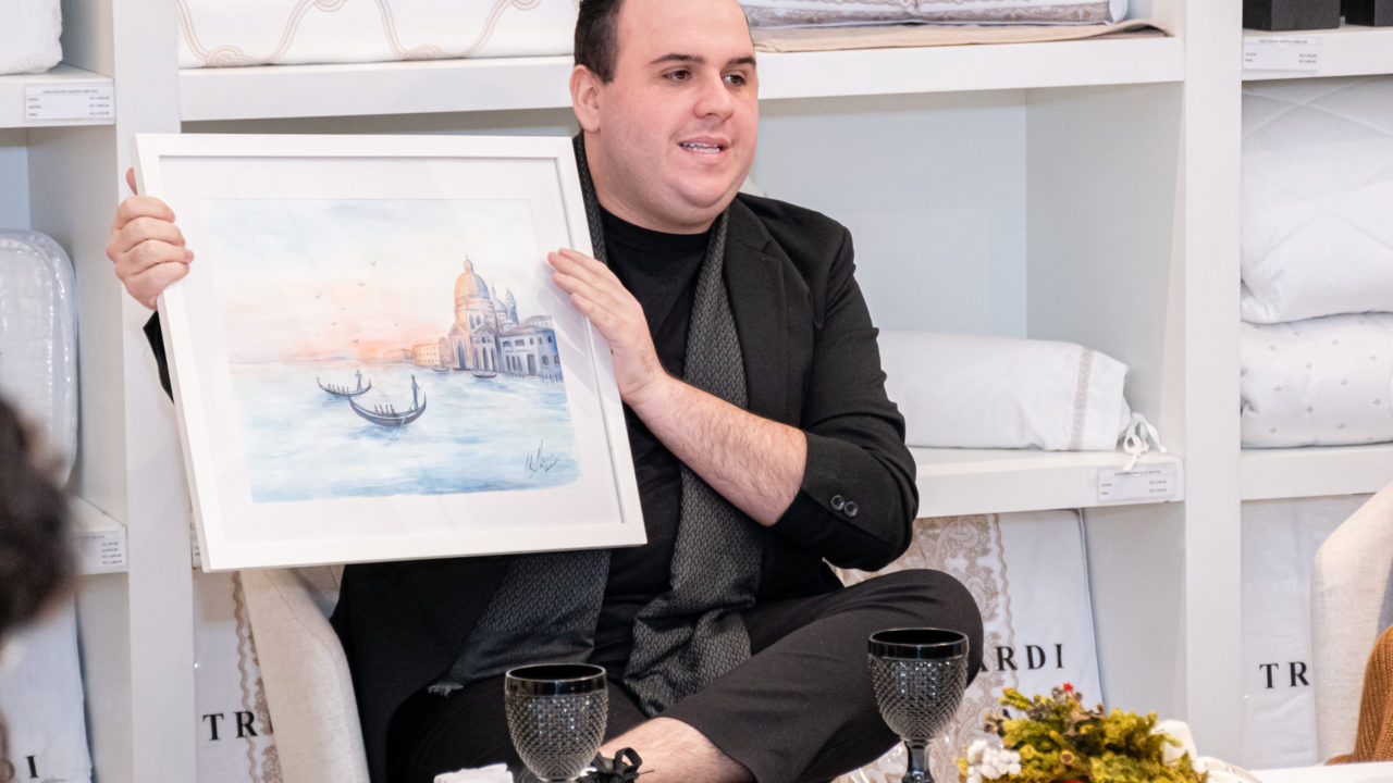 O estilista da Trussardi, Julio Cesar dos Santos, apresenta ao público uma das aquarelas feitas por sua equipe para a coleção La Serenissima, inspirada em Veneza